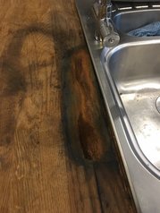 oak kitchen worktop water and metal damage, showing dark marks from tannic acid. Black ring marks and staining before removal.